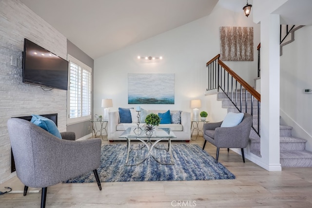 7712 Rockybrook Way, Stanton, CA 90680 - living room featuring vaulted ceiling, stairs, wood finished floors, a stone fireplace, and baseboards