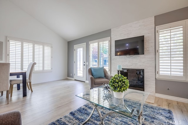 7712 Rockybrook Way, Stanton, CA 90680 - living room with wood finished floors, vaulted ceiling, baseboards, and a fireplace