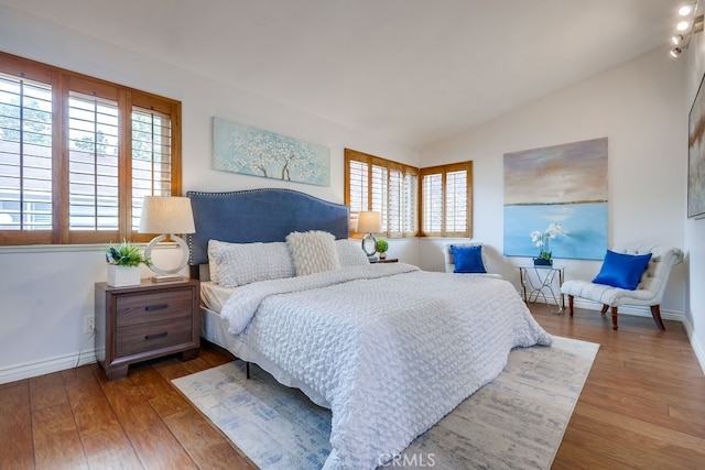 7712 Rockybrook Way, Stanton, CA 90680 - bedroom featuring multiple windows, hardwood / wood-style floors, lofted ceiling, and baseboards