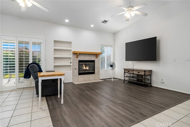 9552 Palm Dr, Desert Hot Springs, CA 92240 - living area with a ceiling fan, plenty of natural light, wood finished floors, a tiled fireplace, and lofted ceiling