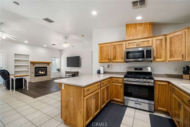 9552 Palm Dr, Desert Hot Springs, CA 92240 - kitchen with appliances with stainless steel finishes, a ceiling fan, vaulted ceiling, light tile patterned floors, and a peninsula