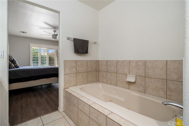 9552 Palm Dr, Desert Hot Springs, CA 92240 - bathroom with ensuite bathroom, a tub with jets, a ceiling fan, tile patterned floors, and a textured ceiling