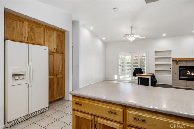 9552 Palm Dr, Desert Hot Springs, CA 92240 - kitchen featuring white refrigerator with ice dispenser, open floor plan, a ceiling fan, a tiled fireplace, and light tile patterned floors