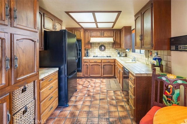537 3rd St, Manhattan Beach, CA 90266 - kitchen featuring tile counters, freestanding refrigerator, backsplash, under cabinet range hood, and brown cabinetry
