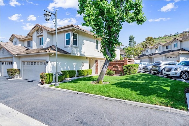 5847 E Rocking Horse Way Unit 21, Orange, CA 92869 - townhome / multi-family property with a residential view, stucco siding, a front lawn, and a garage