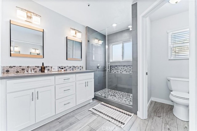 5847 E Rocking Horse Way Unit 21, Orange, CA 92869 - full bathroom with double vanity, a stall shower, toilet, baseboards, and backsplash
