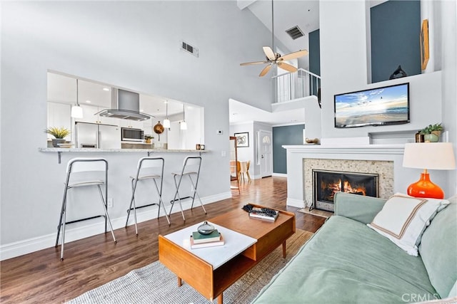 5847 E Rocking Horse Way Unit 21, Orange, CA 92869 - living room featuring wood finished floors, a ceiling fan, baseboards, high vaulted ceiling, and a fireplace with flush hearth
