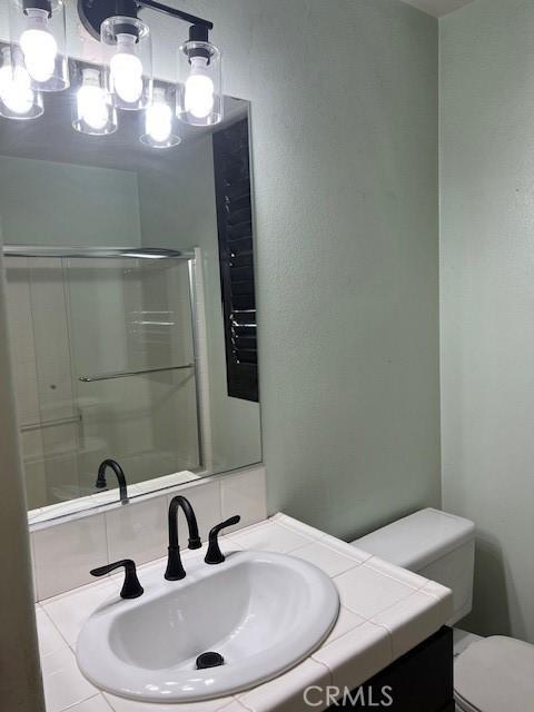 16089 Gables Loop, Whittier, CA 90603 - bathroom featuring vanity, toilet, a chandelier, and a shower with shower door