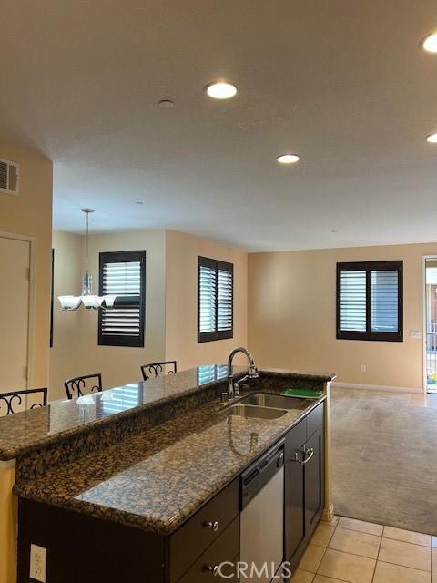 16089 Gables Loop, Whittier, CA 90603 - kitchen with stainless steel dishwasher, a sink, light colored carpet, light tile patterned floors, and recessed lighting