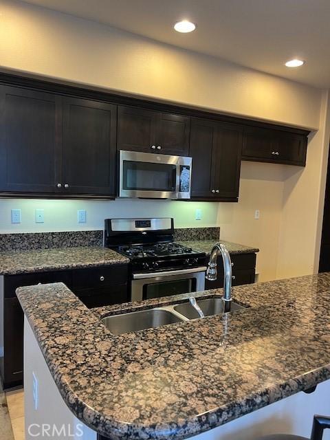 16089 Gables Loop, Whittier, CA 90603 - kitchen featuring stainless steel appliances, dark stone counters, recessed lighting, and a sink