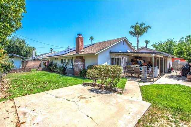1210 3rd St, Calimesa, CA 92320 - back of property featuring a patio area, stucco siding, solar panels, a chimney, and outdoor dining area