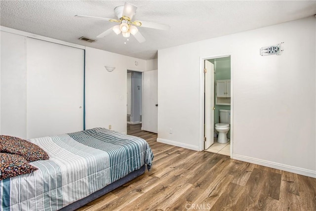 1210 3rd St, Calimesa, CA 92320 - bedroom featuring wood finished floors, a closet, a textured ceiling, connected bathroom, and a ceiling fan