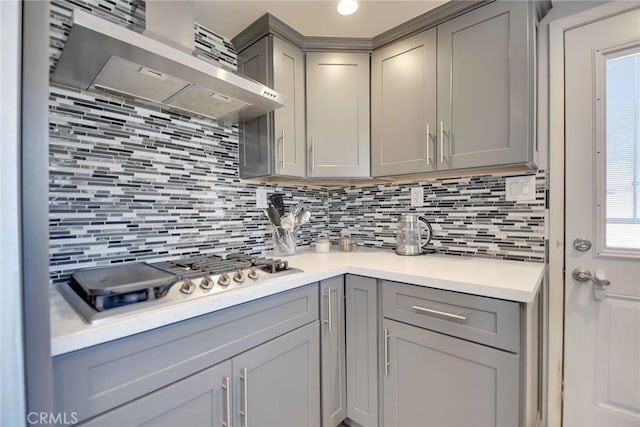 3879 Big Dalton Ave, Baldwin Park, CA 91706 - kitchen featuring gray cabinetry, stainless steel gas cooktop, wall chimney exhaust hood, and tasteful backsplash