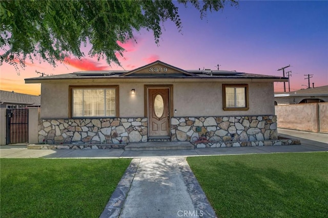 3879 Big Dalton Ave, Baldwin Park, CA 91706 - view of front of property featuring solar panels, stucco siding, a gate, and stone siding