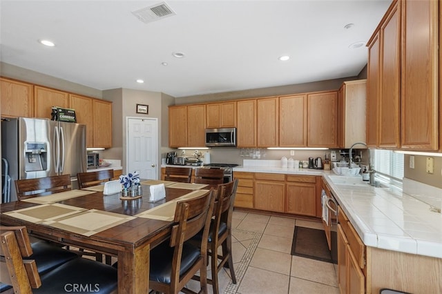 15691 Cherry Leaf Ln, Fontana, CA 92336 - kitchen featuring stainless steel appliances, a sink, light tile patterned flooring, recessed lighting, and tile counters