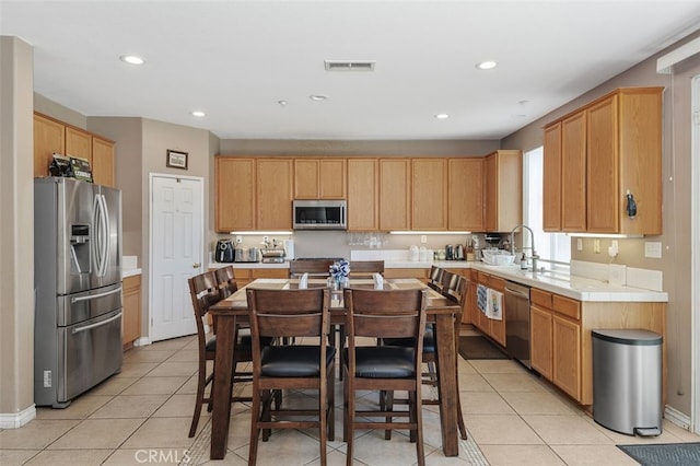 15691 Cherry Leaf Ln, Fontana, CA 92336 - kitchen with appliances with stainless steel finishes, light tile patterned floors, recessed lighting, light brown cabinetry, and baseboards