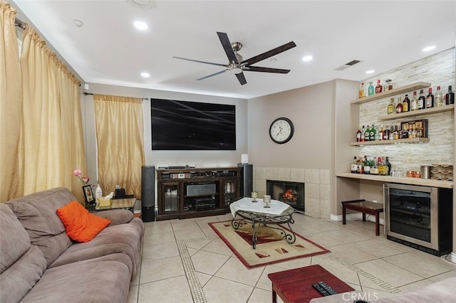 15691 Cherry Leaf Ln, Fontana, CA 92336 - living area with beverage cooler, tile patterned floors, ceiling fan, a bar, and a tiled fireplace