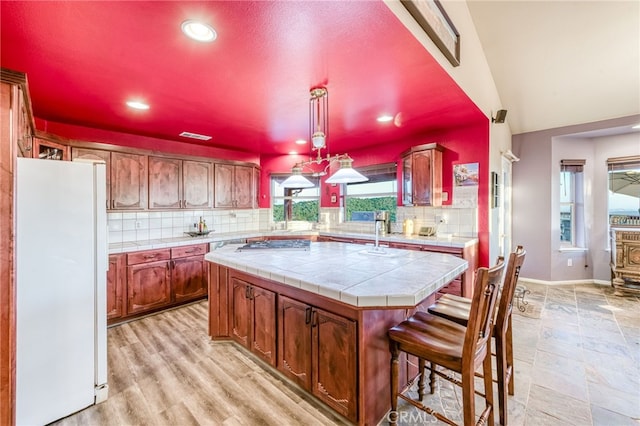 50806 Bramble Ln, Squaw Valley, CA 93675 - kitchen featuring freestanding refrigerator, a center island, tile countertops, decorative backsplash, and recessed lighting