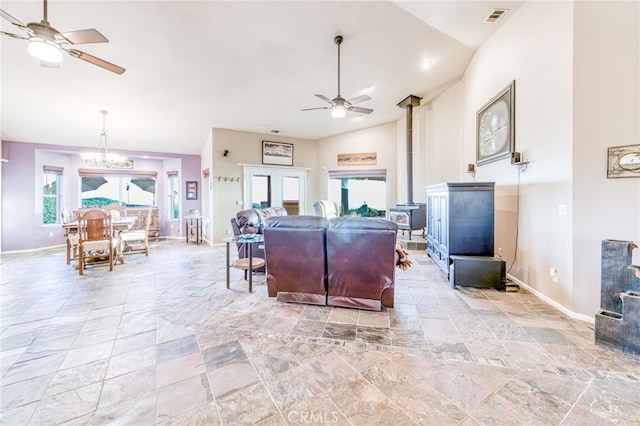 50806 Bramble Ln, Squaw Valley, CA 93675 - living area featuring a ceiling fan, lofted ceiling, a wood stove, light stone finish flooring, and a chandelier