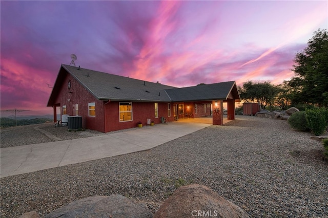 50806 Bramble Ln, Squaw Valley, CA 93675 - back of house at dusk featuring concrete driveway, a shed, and a patio