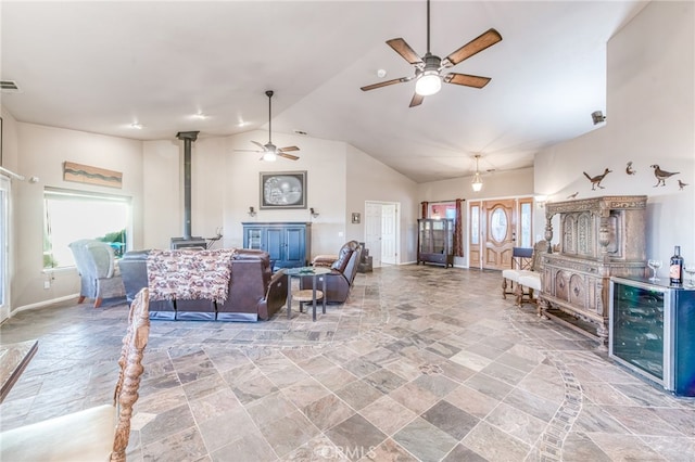 50806 Bramble Ln, Squaw Valley, CA 93675 - living room with stone tile floors, ceiling fan, a wood stove, high vaulted ceiling, and healthy amount of natural light
