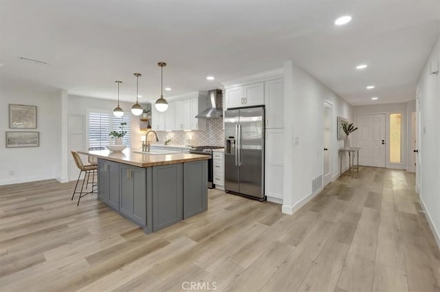 27865 Espinoza, Mission Viejo, CA 92692 - kitchen featuring appliances with stainless steel finishes, wall chimney exhaust hood, a sink, light wood finished floors, and recessed lighting