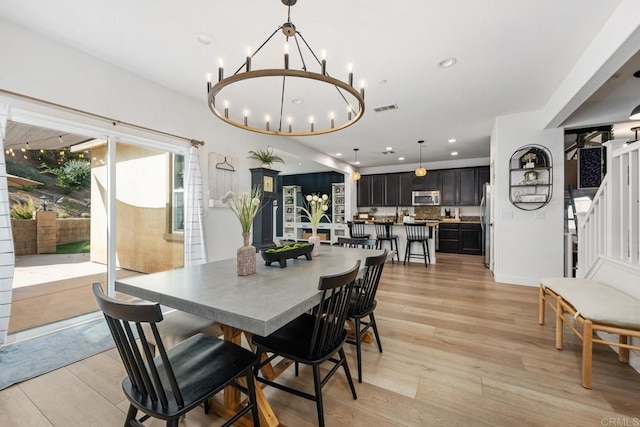 25444 Red Hawk Rd, Corona, CA 92883 - dining room with a chandelier, light wood-style flooring, stairway, and recessed lighting
