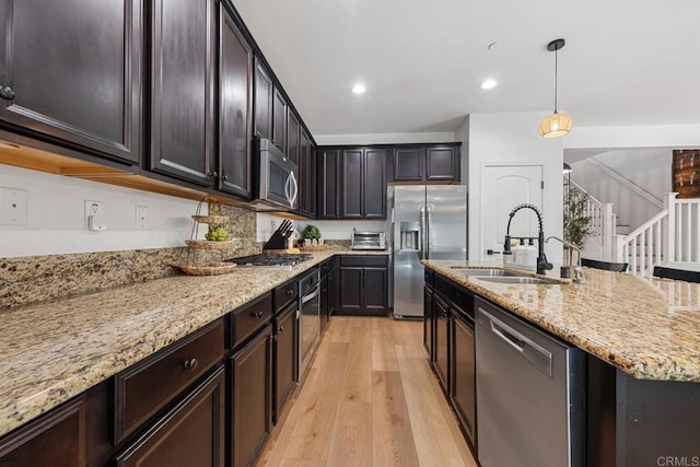 25444 Red Hawk Rd, Corona, CA 92883 - kitchen featuring stainless steel appliances, a sink, light wood-style flooring, light stone counters, and decorative light fixtures