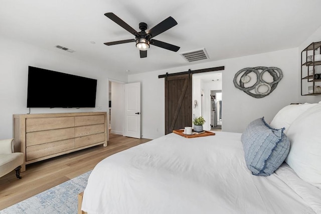 25444 Red Hawk Rd, Corona, CA 92883 - bedroom with a barn door, wood finished floors, and ceiling fan