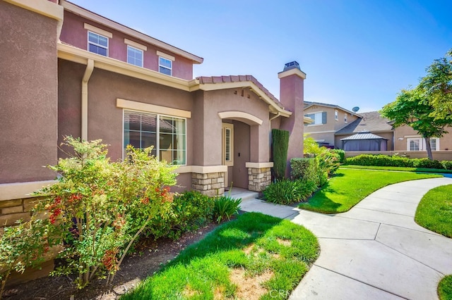 39723 Columbia Union Dr Unit A, Murrieta, CA 92563 - view of front of house with stucco siding, a front lawn, a chimney, and stone siding
