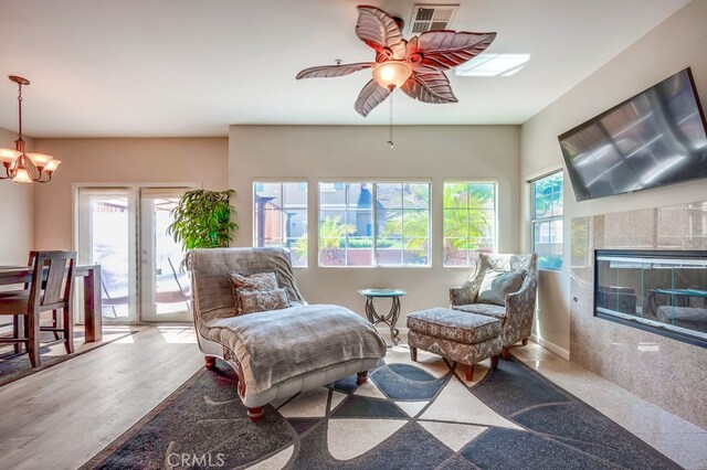 39723 Columbia Union Dr Unit A, Murrieta, CA 92563 - sitting room featuring healthy amount of natural light, a ceiling fan, a chandelier, and a glass covered fireplace
