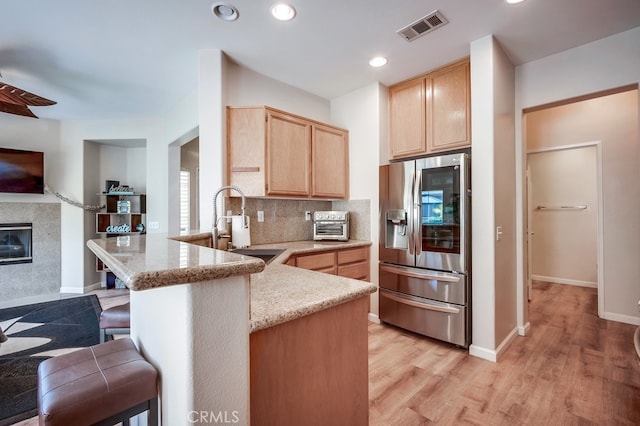 39723 Columbia Union Dr Unit A, Murrieta, CA 92563 - kitchen featuring stainless steel refrigerator with ice dispenser, light brown cabinets, a peninsula, a sink, and a breakfast bar