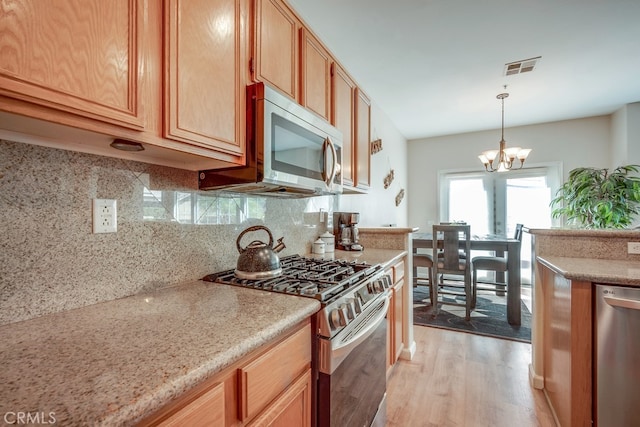 39723 Columbia Union Dr Unit A, Murrieta, CA 92563 - kitchen with stainless steel appliances, light wood-type flooring, a chandelier, decorative backsplash, and decorative light fixtures