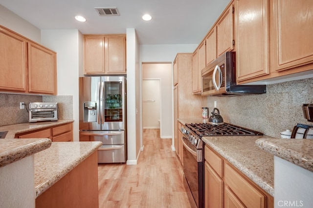 39723 Columbia Union Dr Unit A, Murrieta, CA 92563 - kitchen featuring stainless steel appliances, light brown cabinetry, light wood-style floors, backsplash, and light stone countertops