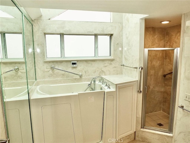 5510 E La Pasada St E, Long Beach, CA 90815 - bathroom featuring a bath, a stall shower, and tile walls
