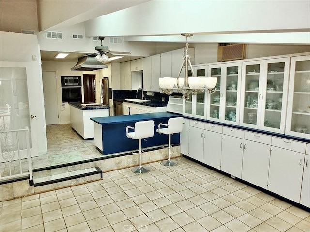 5510 E La Pasada St E, Long Beach, CA 90815 - kitchen featuring built in microwave, black oven, dark countertops, a sink, and light tile patterned floors
