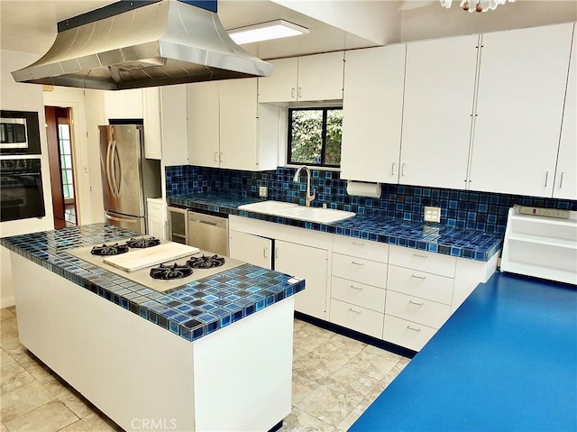 5510 E La Pasada St E, Long Beach, CA 90815 - kitchen featuring stainless steel appliances, a sink, wall chimney exhaust hood, tile counters, and white cabinetry
