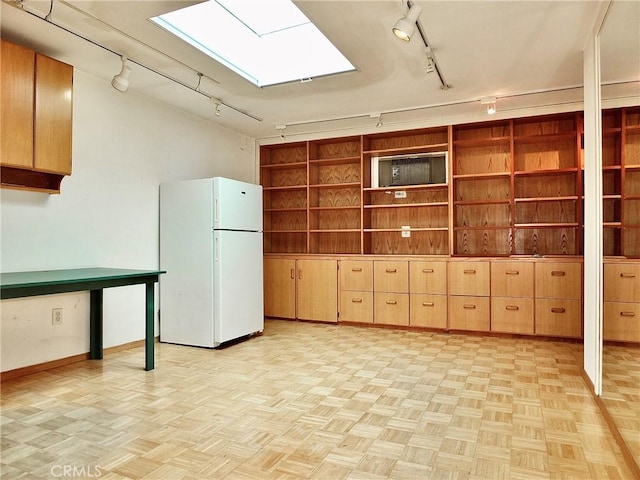5510 E La Pasada St E, Long Beach, CA 90815 - below grade area featuring freestanding refrigerator, rail lighting, and baseboards