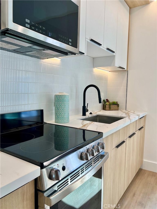 6829 Yolanda Ave, Reseda, CA 91335 - kitchen featuring appliances with stainless steel finishes, a sink, light wood-type flooring, light stone countertops, and tasteful backsplash