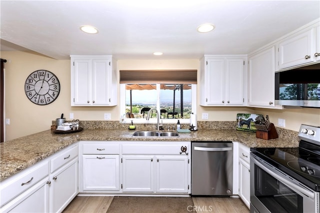 40125 Scanlon Rd, Temecula, CA 92592 - kitchen with stainless steel appliances, a sink, white cabinetry, recessed lighting, and light stone counters