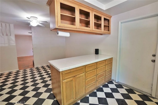 2306 S Encina St, Visalia, CA 93277 - kitchen featuring tile patterned floors, a ceiling fan, glass insert cabinets, and tile countertops