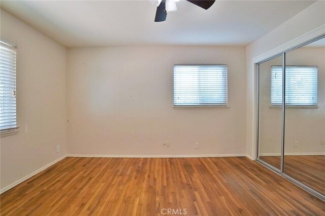 2306 S Encina St, Visalia, CA 93277 - unfurnished bedroom featuring wood finished floors, a closet, baseboards, and ceiling fan