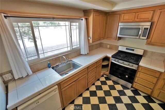 2306 S Encina St, Visalia, CA 93277 - kitchen featuring appliances with stainless steel finishes, a sink, tile countertops, and plenty of natural light