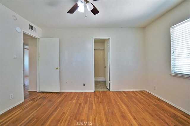 2306 S Encina St, Visalia, CA 93277 - unfurnished bedroom featuring light wood-type flooring, baseboards, and connected bathroom