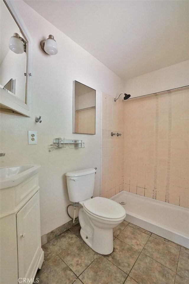 2306 S Encina St, Visalia, CA 93277 - bathroom with a tile shower, toilet, vanity, tile patterned flooring, and baseboards