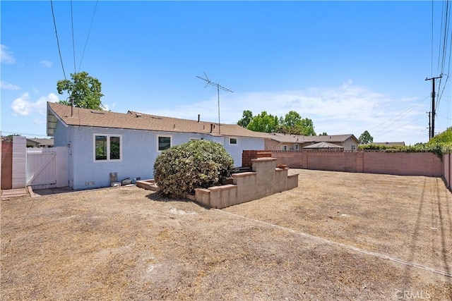 11747 Hollyview Dr, La Mirada, CA 90638 - rear view of house featuring a fenced backyard, stucco siding, and a gate