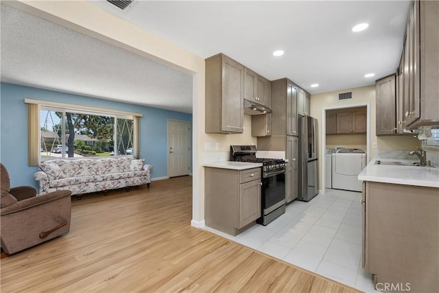 11747 Hollyview Dr, La Mirada, CA 90638 - kitchen with stainless steel appliances, a sink, washer and dryer, under cabinet range hood, and open floor plan
