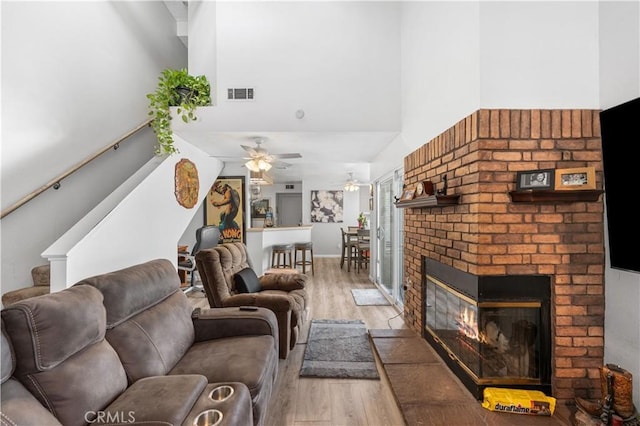 37940 42nd St E Unit 115, Palmdale, CA 93552 - living area with light wood finished floors, a high ceiling, a ceiling fan, stairs, and a fireplace