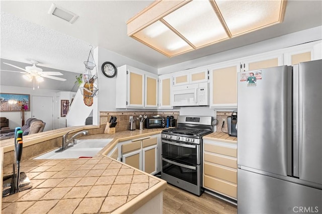 37940 42nd St E Unit 115, Palmdale, CA 93552 - kitchen featuring appliances with stainless steel finishes, a sink, a ceiling fan, light wood-style flooring, and white cabinetry