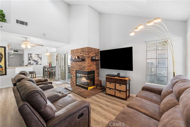 37940 42nd St E Unit 115, Palmdale, CA 93552 - living area featuring a fireplace, light wood-style flooring, healthy amount of natural light, and a high ceiling